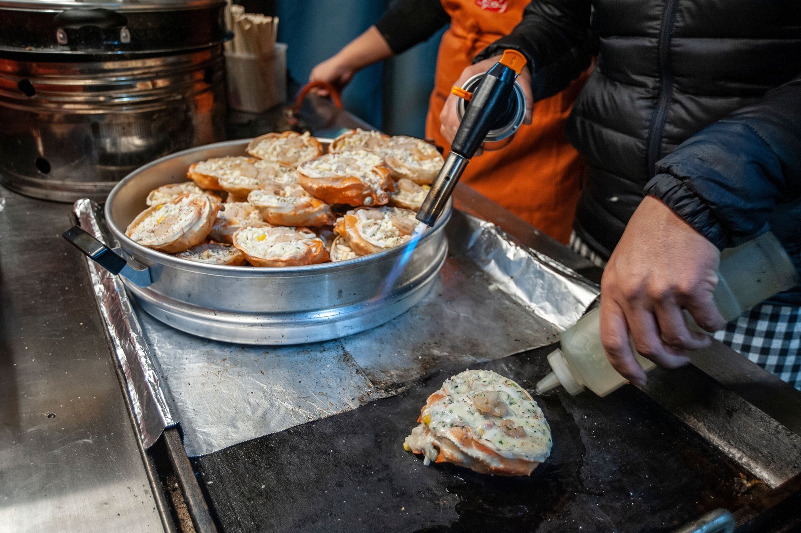 Street snacks on a hot griddle at Seomun Market