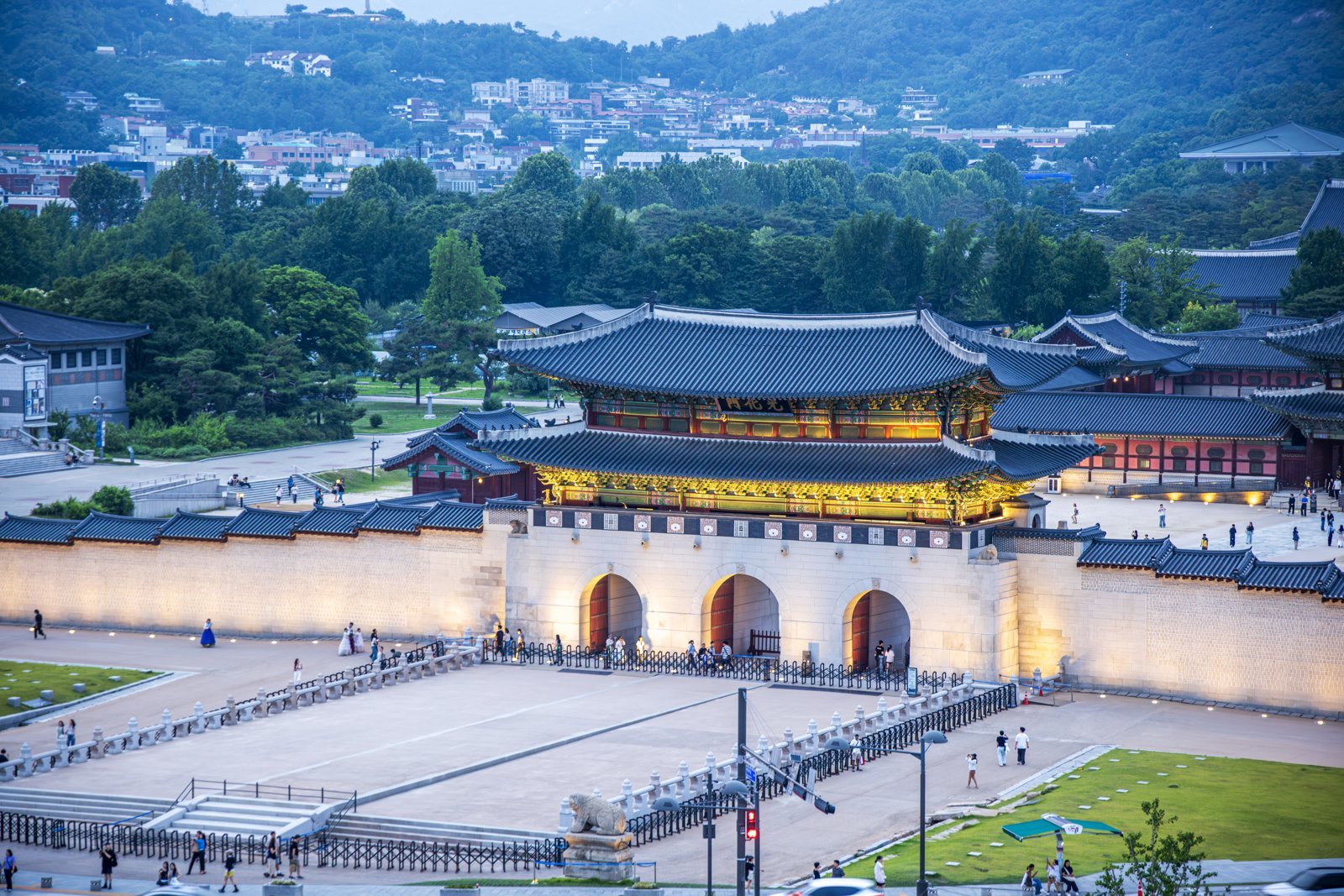 Gwanghwamun Gate at dusk, with Gyeongbokgung spread out behind it and Bugaksan Mountain in the distance (June 2026)