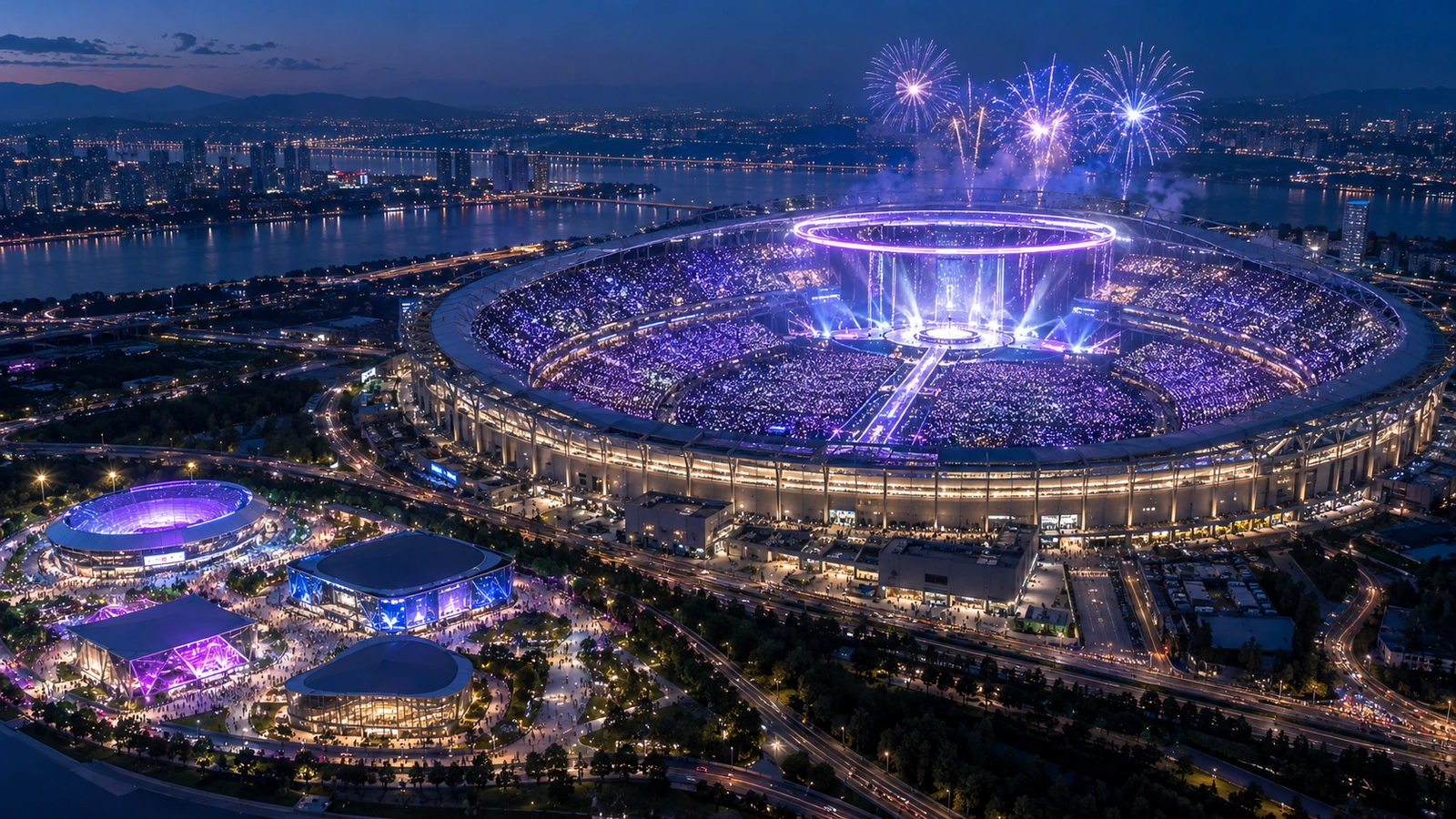 Aerial view of a huge stadium full of lavender light sticks, fireworks, smaller venues glowing nearby