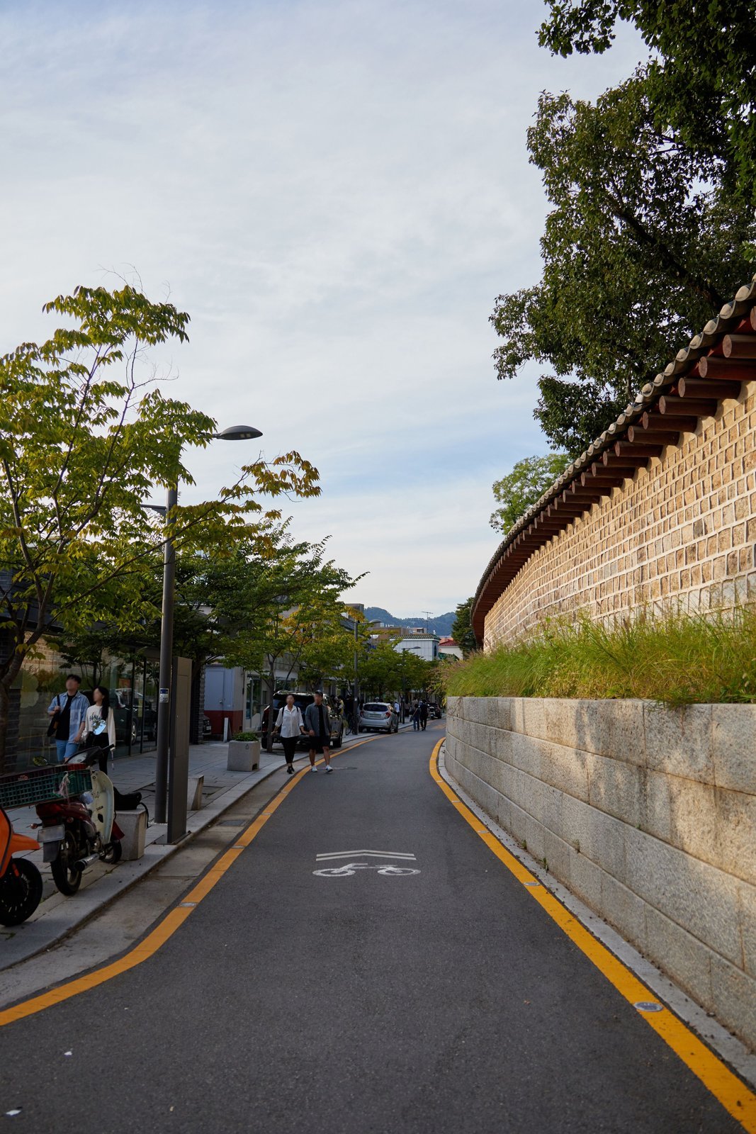 Seosulla-gil in the afternoon: Jongmyo's wall on the left, workshops and cafés on the right (October 2023)