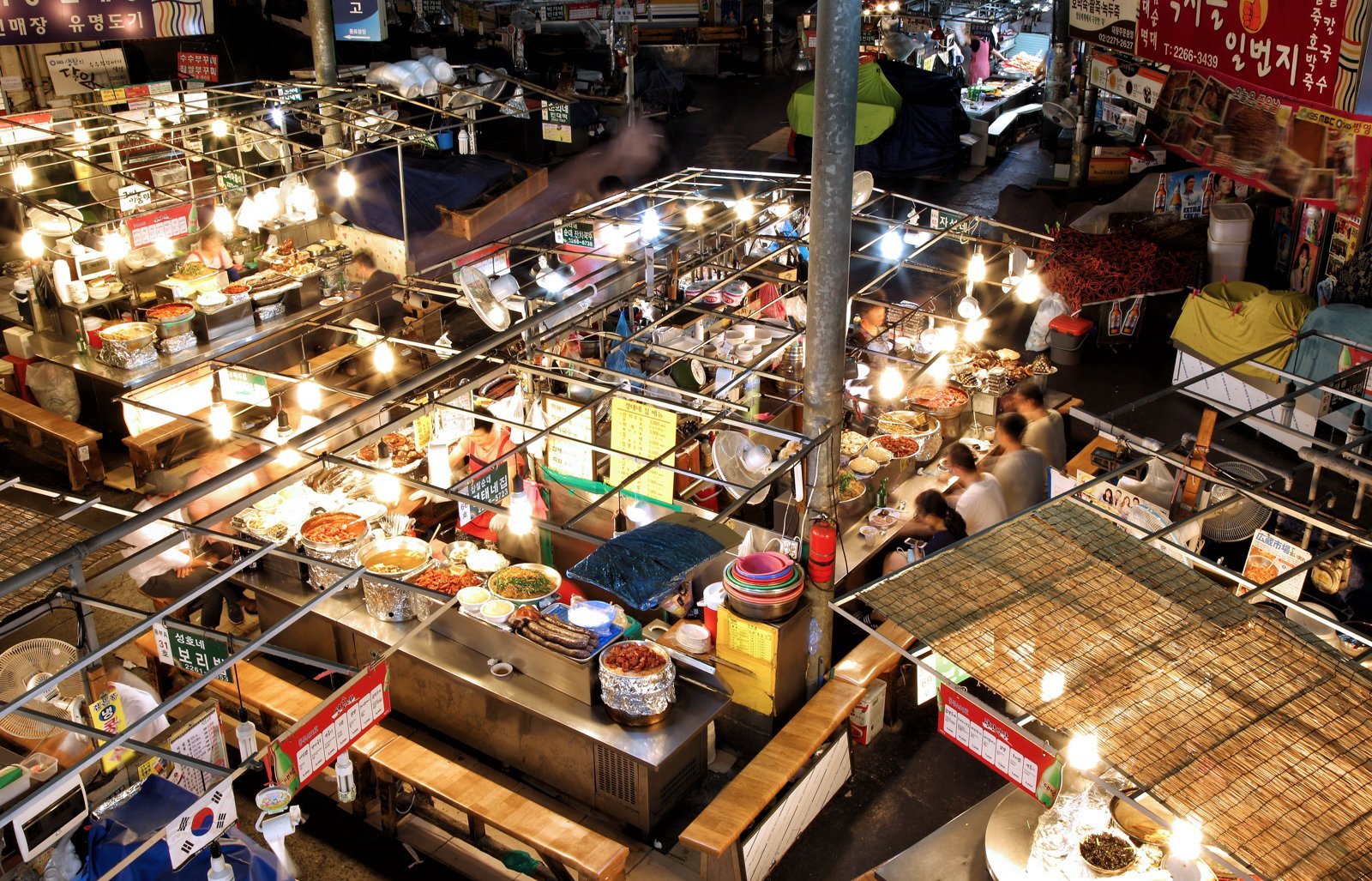 The food alley at Gwangjang Market. Sit at a center stall and order bindaetteok and makgeolli