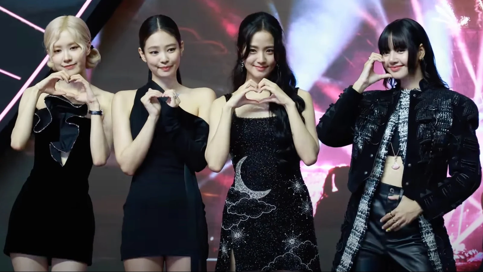 BLACKPINK members ROSÉ, JENNIE, JISOO and LISA smiling and making heart gestures in black outfits on stage. Photo: TV10 via YouTube/Wikimedia Commons, CC BY 3.0