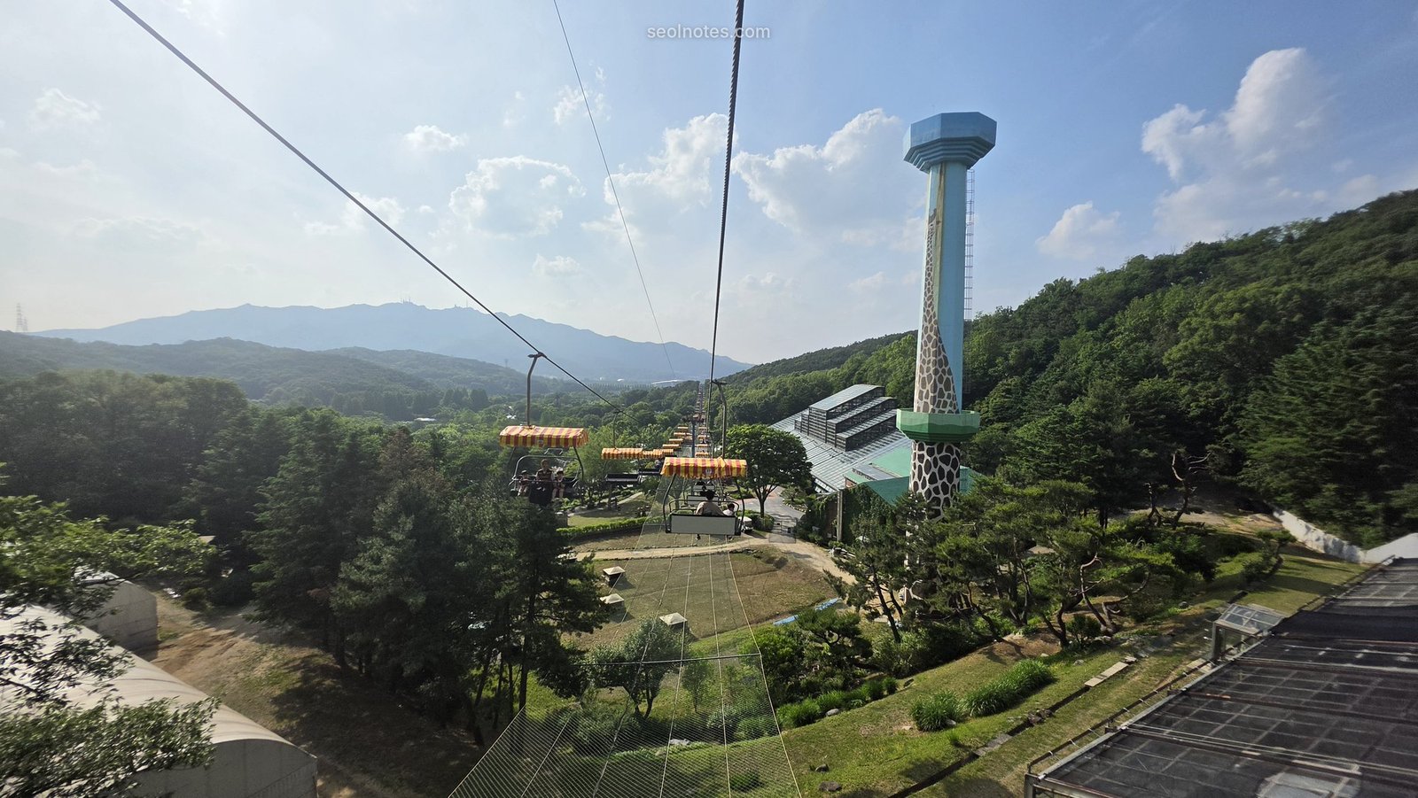 Cable cars crossing green hills toward an observation tower