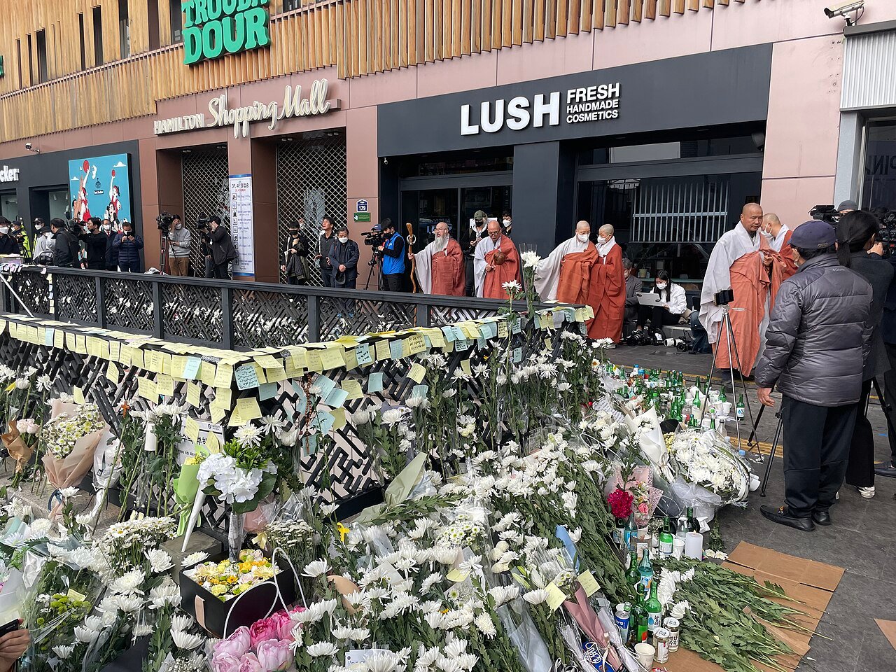 Flowers, notes and Buddhist monks at the memorial outside Itaewon Station Exit 1, November 2022